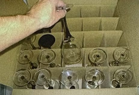 Verres à pied rangés un par un dans un carton à croisillons